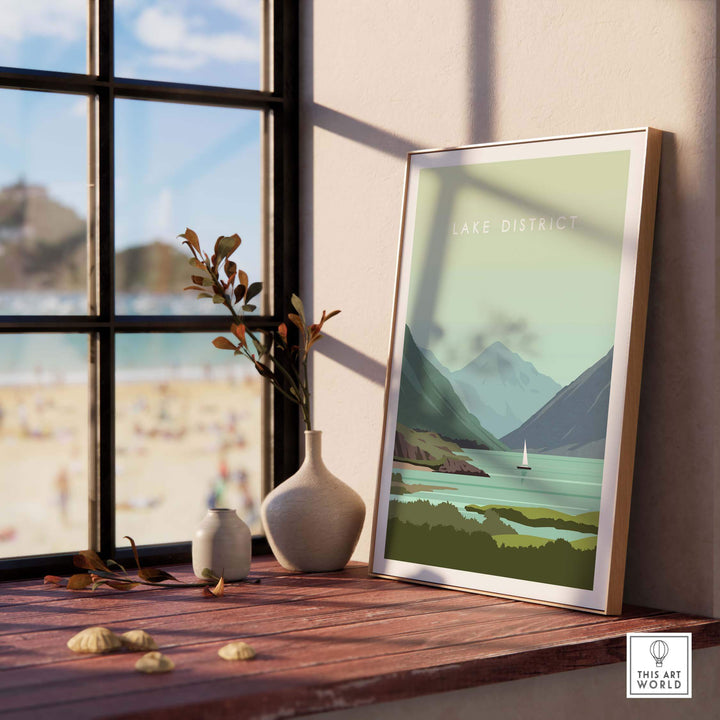 Lake District Print Wall Art Poster displayed on a wooden table with a scenic view through a window.