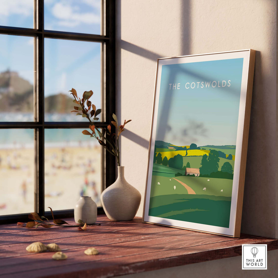 The Cotswolds poster print displayed indoors, featuring a serene landscape with rolling hills and a quaint cottage.