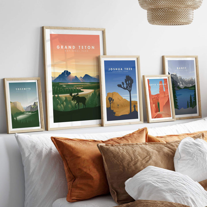 Framed art prints of Grand Teton, Joshua Tree, and other national parks on a stylish wall above a cozy bed.