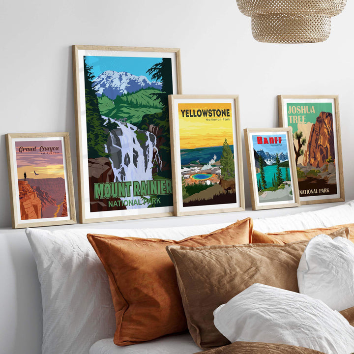 Framed Mount Rainier National Park print and vintage posters displayed on a wall above a cozy bed.
