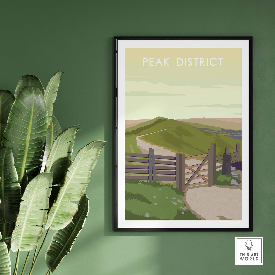 Framed Peak District travel poster art print on green wall with tropical plant, showcasing scenic hills and gate.