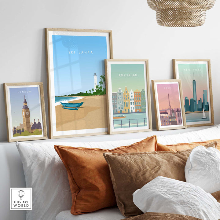 Framed Sri Lanka travel poster print alongside other city-themed art on a modern couch with decorative pillows.
