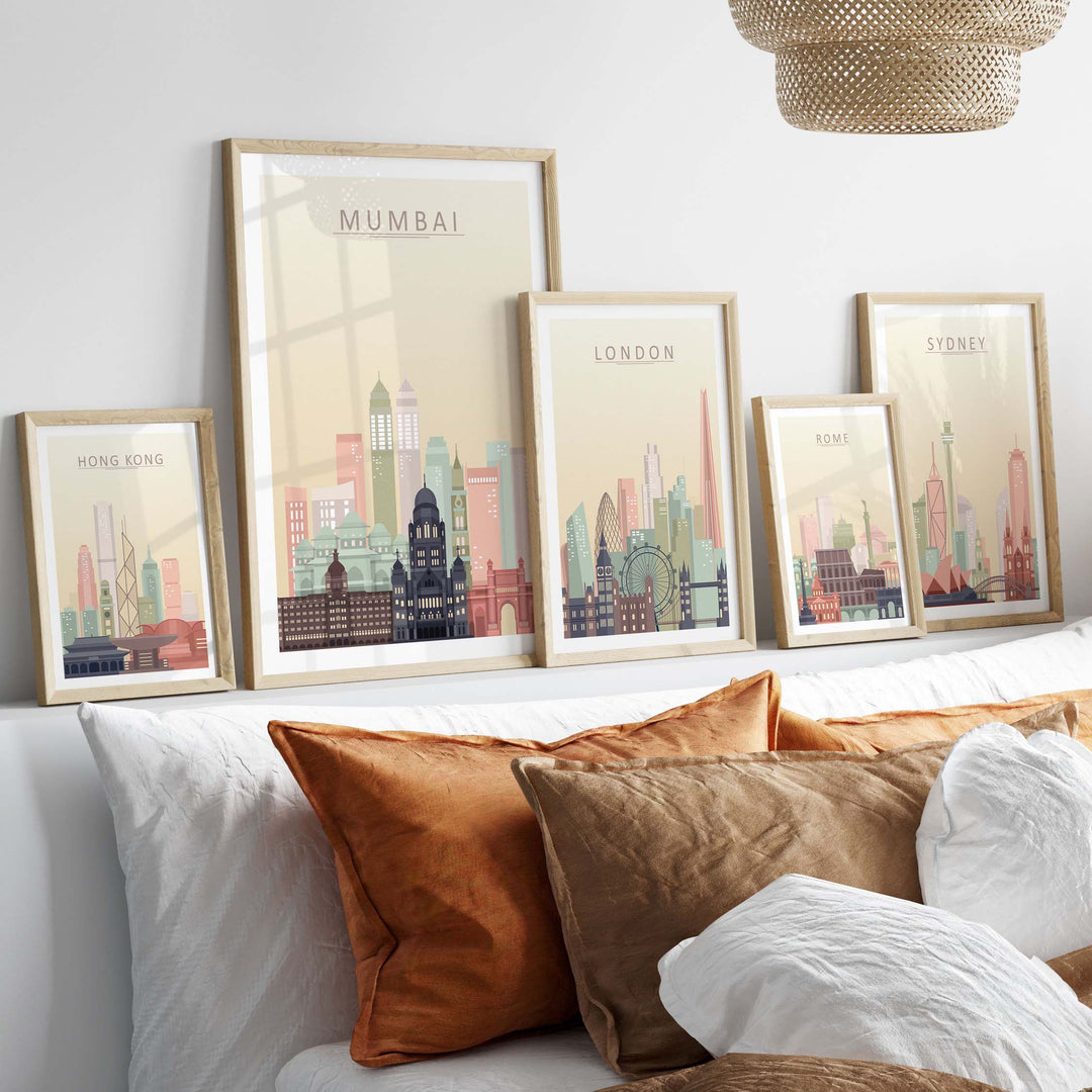 Framed Mumbai Skyline Wall Art Print among other city skyline prints in warm pastel tones on a stylish sofa.