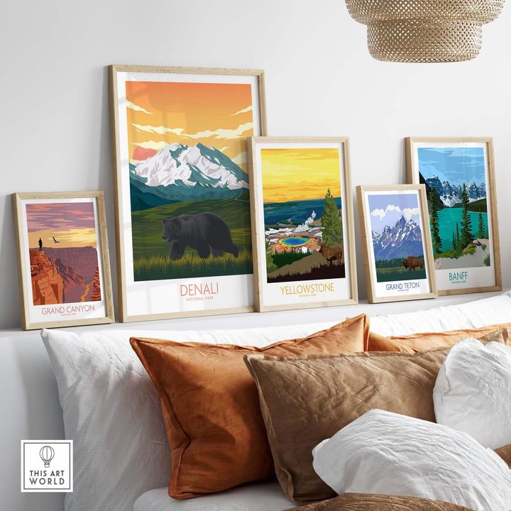 Collection of framed National Park art prints including Denali, Yellowstone, Grand Canyon, and Banff on a stylish sofa.