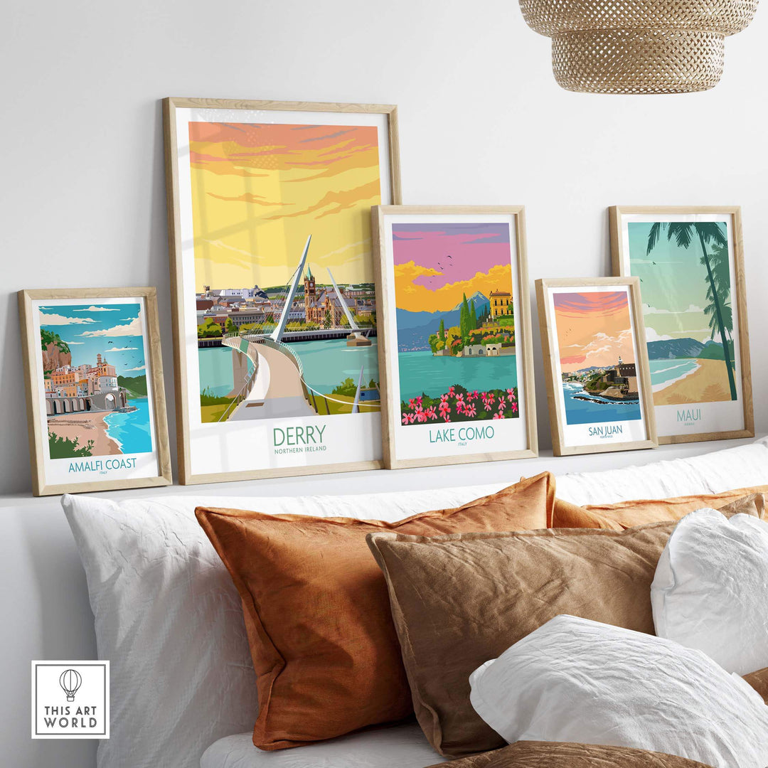 Framed Derry Print and other travel art posters displayed on a stylish sofa in a cozy living room setting.
