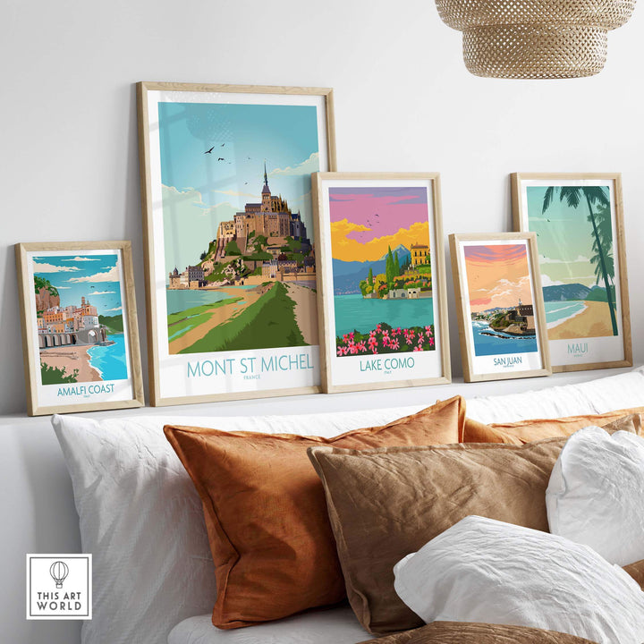 Mont Saint Michel Print and other vintage travel art displayed on a stylish shelf with decorative pillows.