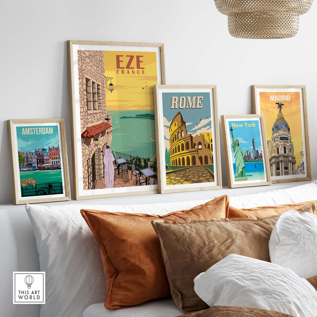 Eze France Poster Print Wall Art displayed with vintage travel prints of Amsterdam, Rome, and Madrid on a stylish sofa.
