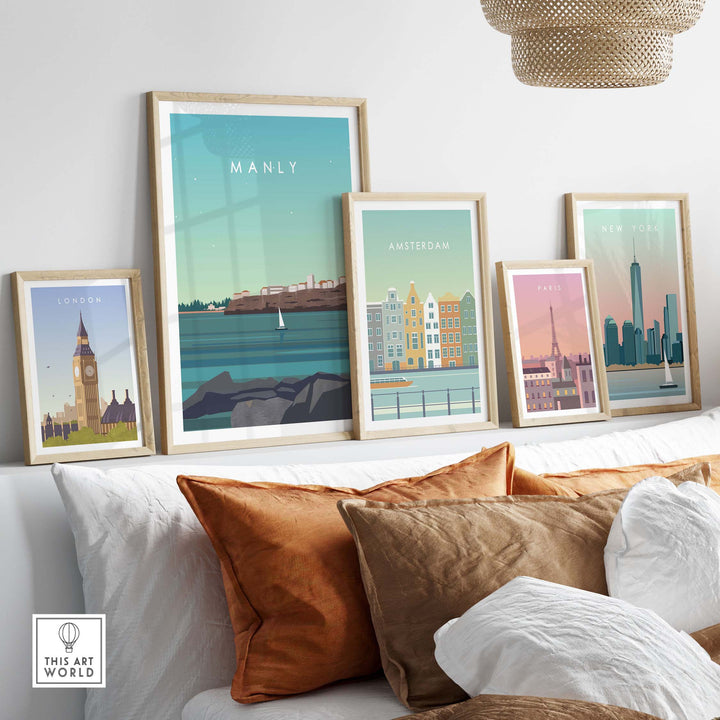 Framed travel poster prints featuring Manly, Amsterdam, London, Paris, and New York on a stylish couch.