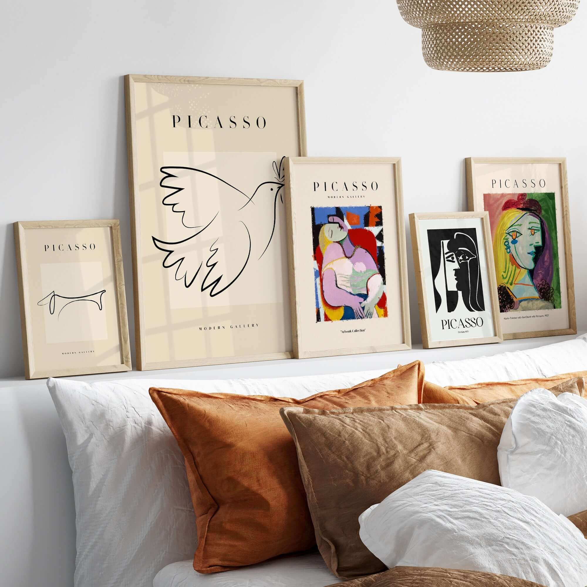 Collection of Pablo Picasso art prints framed on a wall with stylish decor and modern cushions.