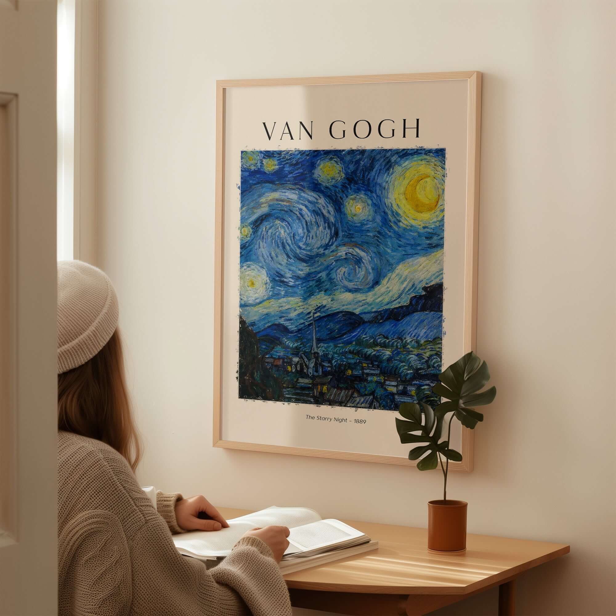 Person reading under a Van Gogh print titled 'The Starry Night' on a wall, showcasing vibrant colors.