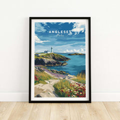Anglesey Wales travel poster print in black frame, coastal landscape with lighthouse and wildflowers