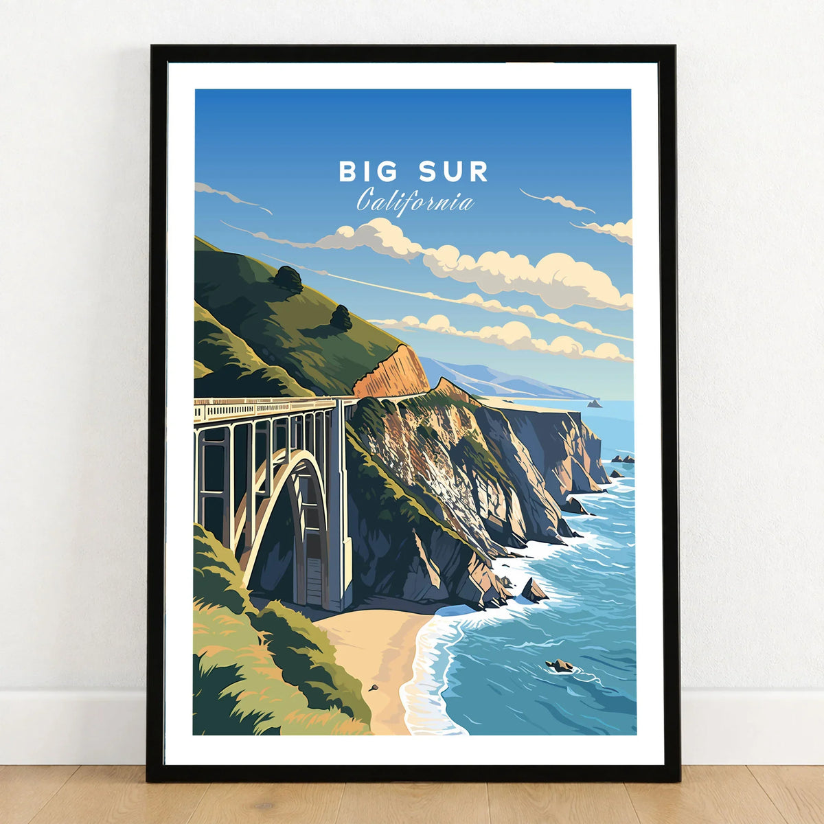 Big Sur Print in a black wooden frame leaning against a white wall on a light wooden floor