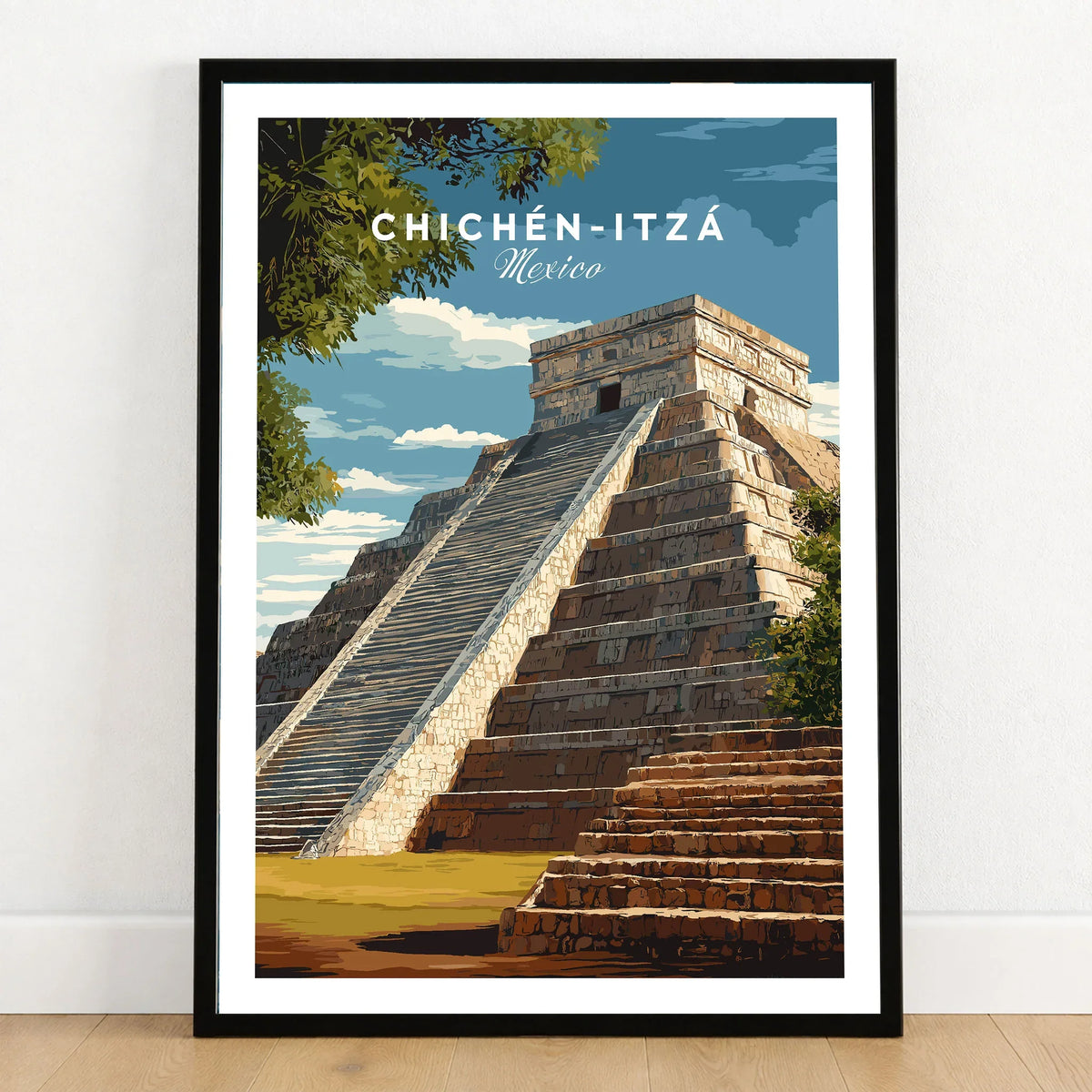 Chichén Itzá Mexico Travel Print El Castillo Pyramid Poster Mayan Ruins Wall Art in a black wooden frame leaning against a white wall on a light wooden floor