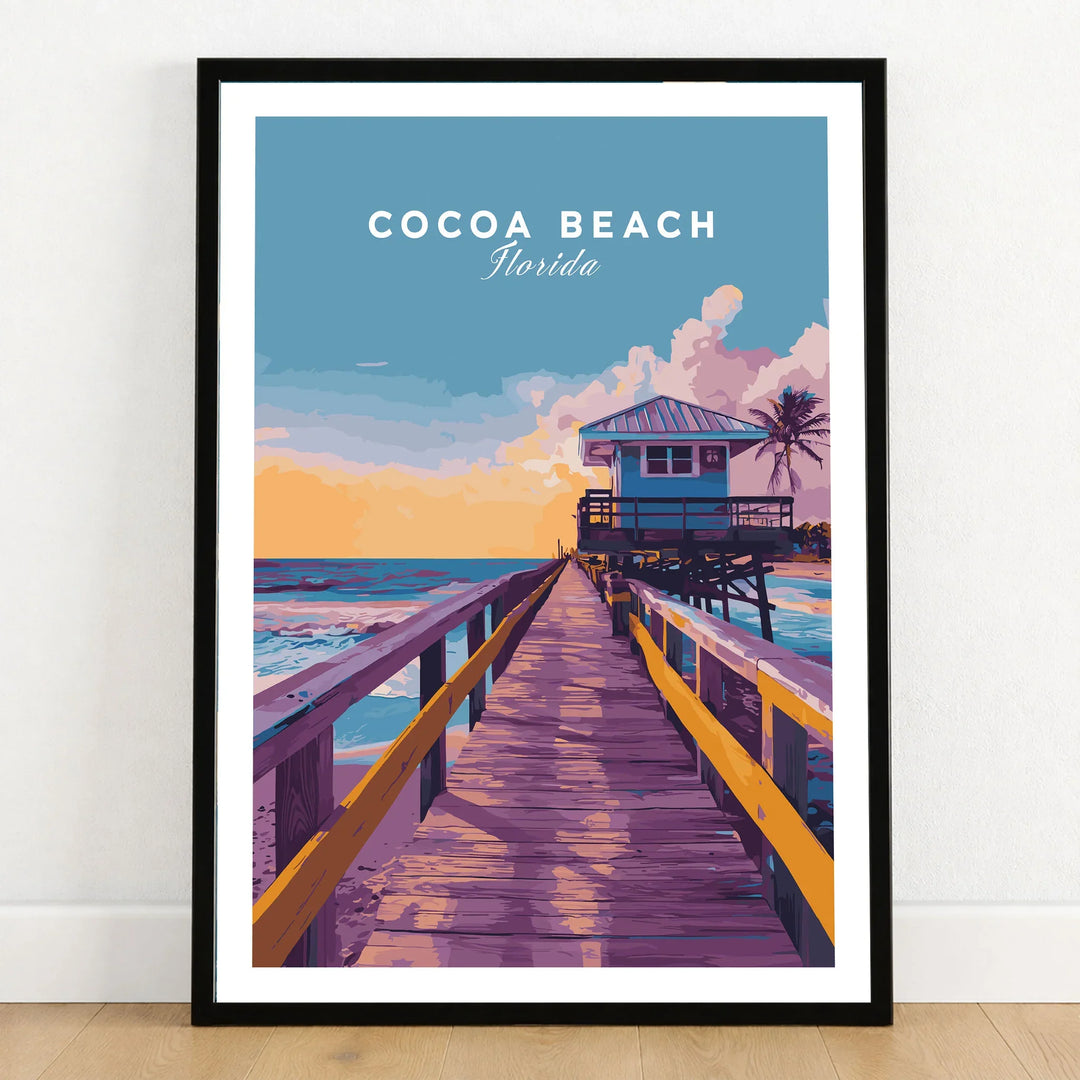 Cocoa Beach Boardwalk Print - Florida Sunset Wall Art in a black wooden frame leaning against a white wall on a light wooden floor
