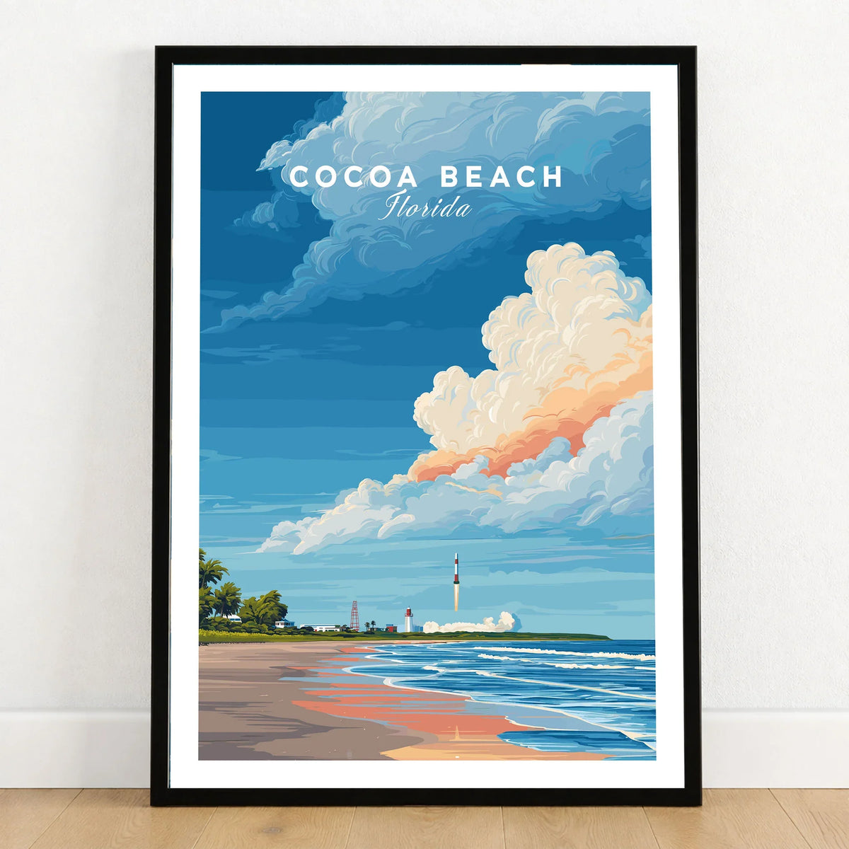 Cocoa Beach Florida Rocket Launch Print - Space Coast Wall Art in a black wooden frame leaning against a white wall on a light wooden floor