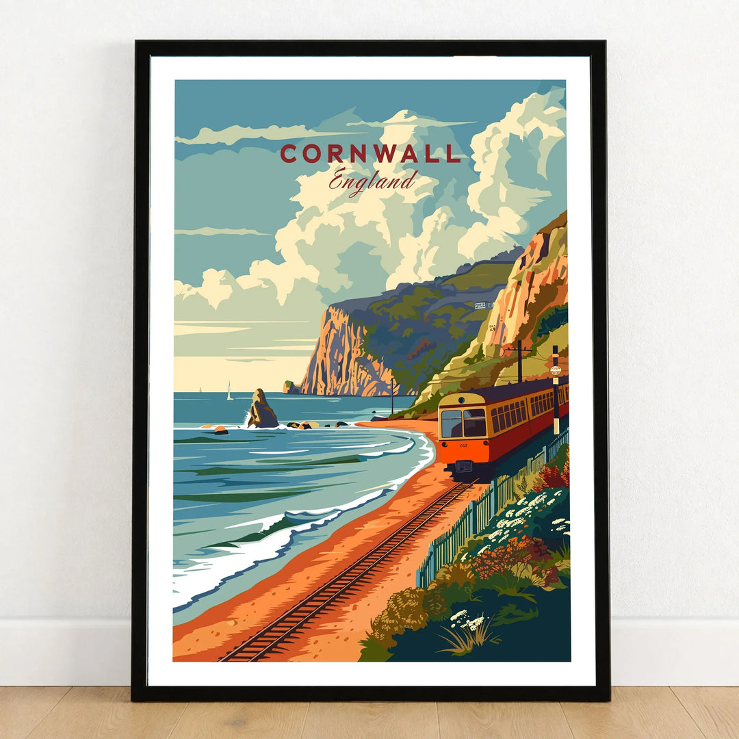 Cornwall Coast Travel Print in a black wooden frame leaning against a white wall on a light wooden floor