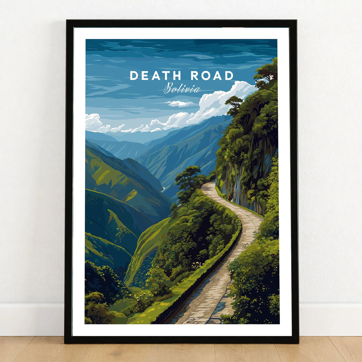 Death Road Andes Print | Yungas Road Poster in a black wooden frame leaning against a white wall on a light wooden floor