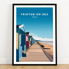 Frinton-on-Sea Travel Poster – Essex Coastline Beach Huts & Prom Art in a black wooden frame leaning against a white wall on a light wooden floor
