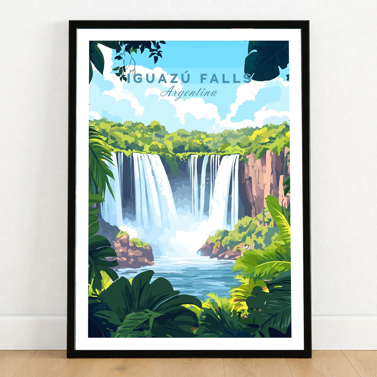 Iguazu Falls Travel Print in a black wooden frame leaning against a white wall on a light wooden floor