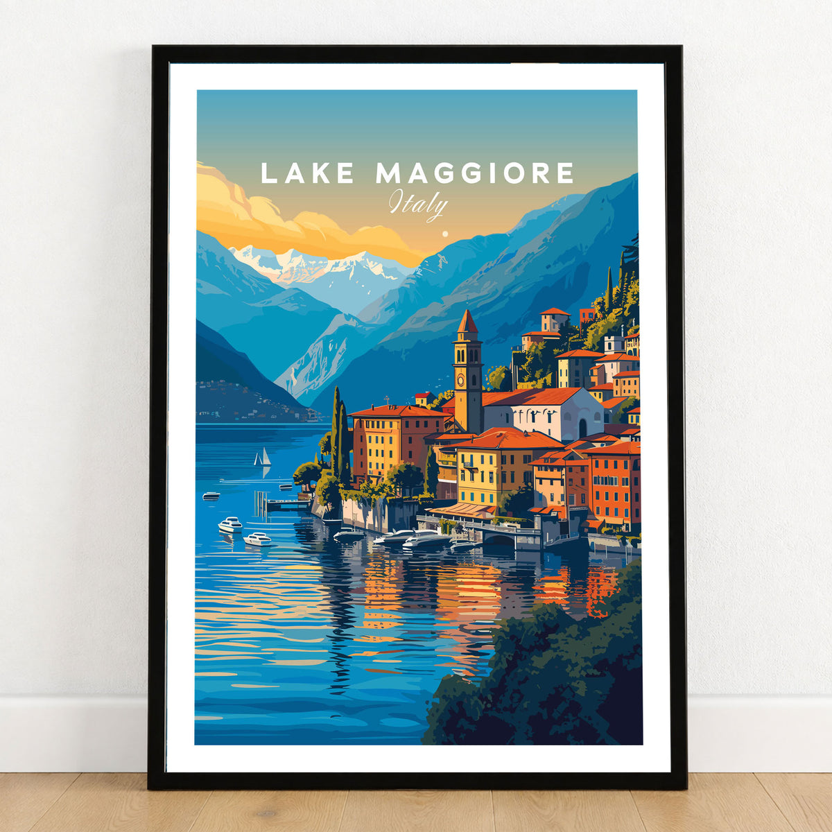 Lake Maggiore Print in a black wooden frame leaning against a white wall on a light wooden floor