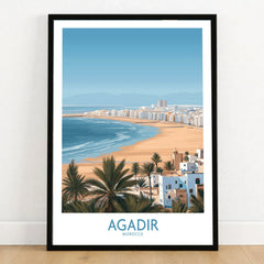 Agadir Morocco Print – Panoramic Beach and Palm Tree Wall Decor in a black wooden frame leaning against a white wall on a light wooden floor