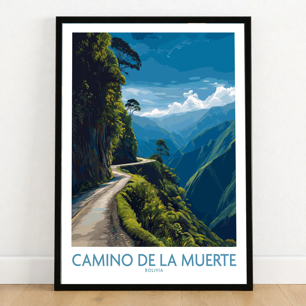 Camino de la Muerte Bolivia Cliff Road Wall Art — the Yungas cliff road curving along a jungle mountainside above the Bolivian Andes, shown as art print in black frame on wooden floor
