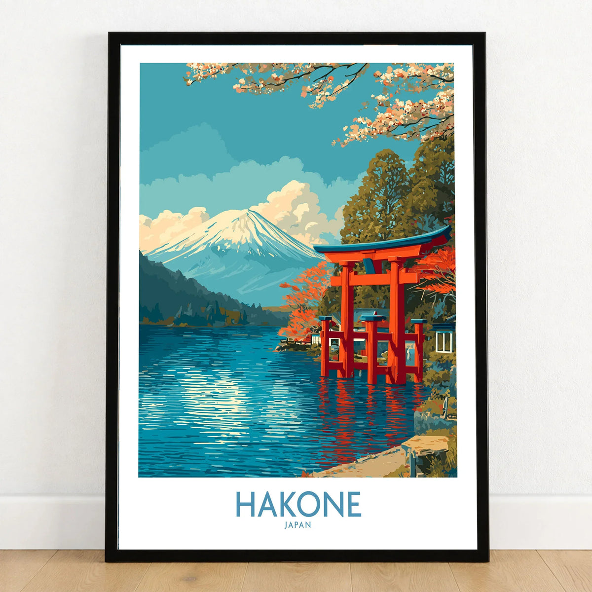 Hakone Wall Art Japan Red Torii Gate Poster in a black wooden frame leaning against a white wall on a light wooden floor