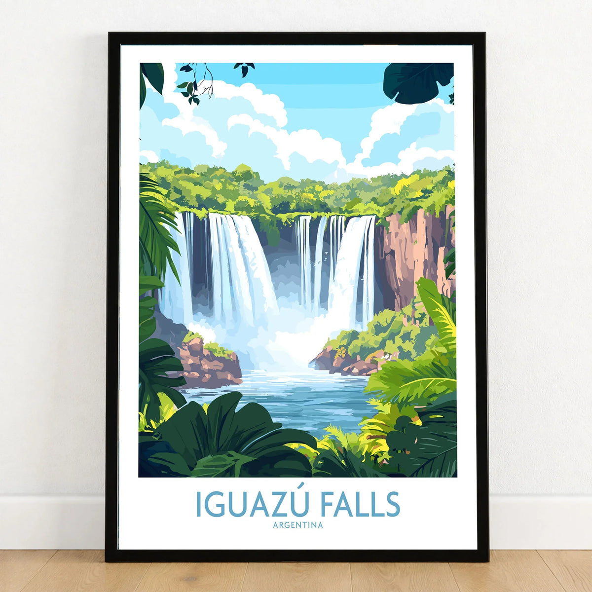 Iguazu Falls Travel Poster in a black wooden frame leaning against a white wall on a light wooden floor