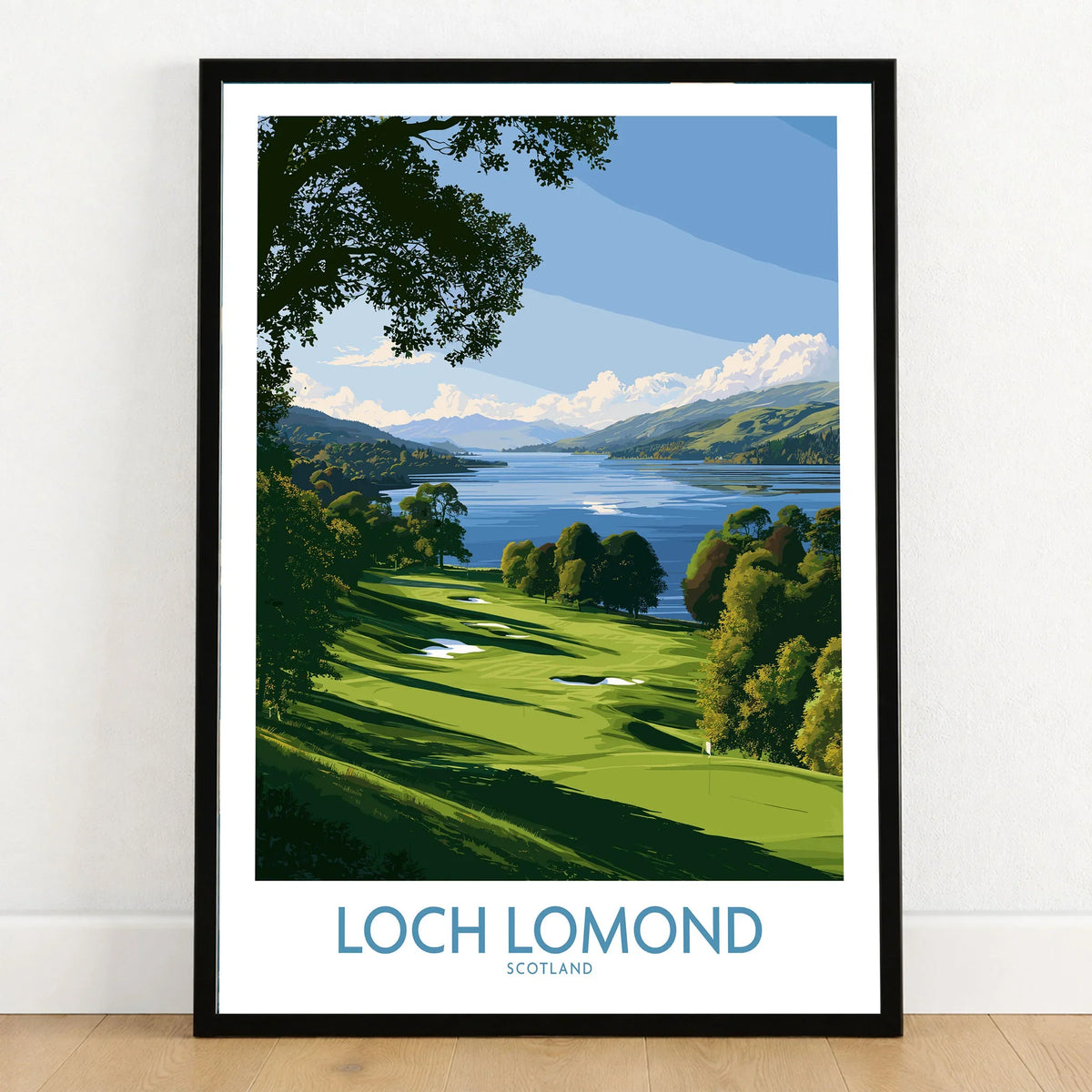 Loch Lomond Scotland Lochside Meadow Wall Art — a sunlit grassy shoreline running down to Loch Lomond under old oaks, shown as art print in black frame on wooden floor