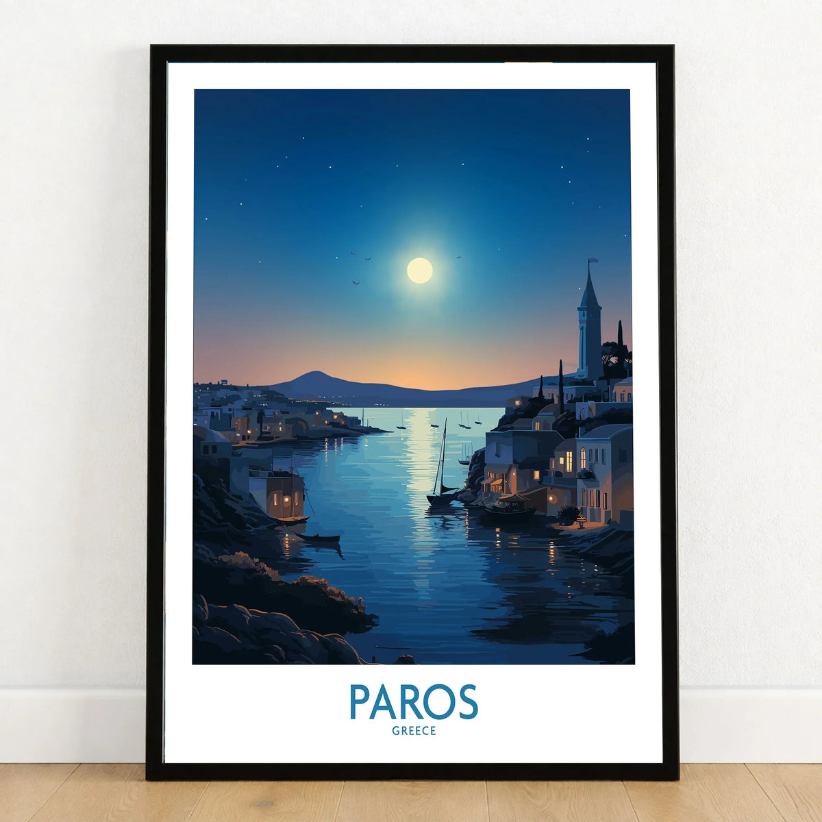 Paros Poster Greece in a black wooden frame leaning against a white wall on a light wooden floor