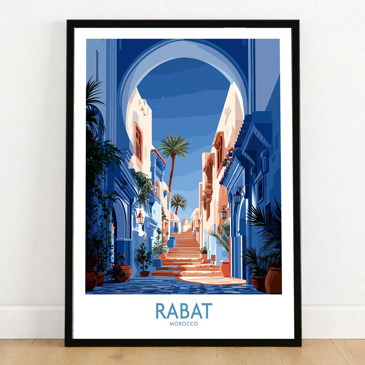 Rabat Morocco Blue Alleyway Wall Art — a blue-washed medina lane and stone steps seen through a horseshoe arch, shown as art print in black frame on wooden floor