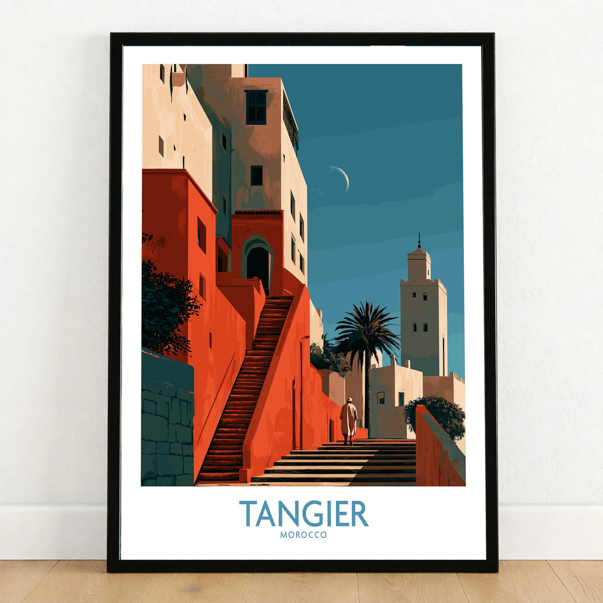 Tangier Morocco Crescent Moon Wall Art — coral kasbah steps climbing towards a minaret under a crescent moon, shown as art print in black frame on wooden floor