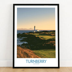 Turnberry Scotland Rocky Shore Wall Art — the Turnberry lighthouse above a rocky shore with the Arran hills beyond, shown as art print in black frame on wooden floor