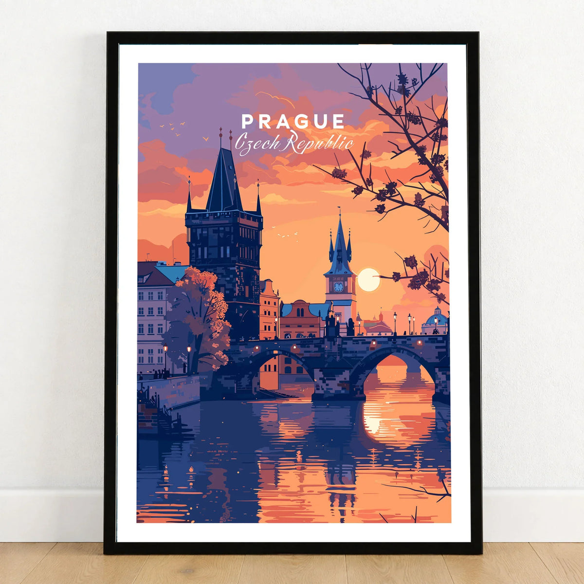 Prague Poster in a black wooden frame leaning against a white wall on a light wooden floor