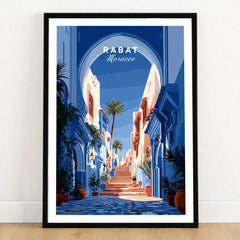 Rabat Morocco Blue Medina Travel Poster — a blue-washed medina lane and stone steps seen through a horseshoe arch, shown as art print in black frame on wooden floor