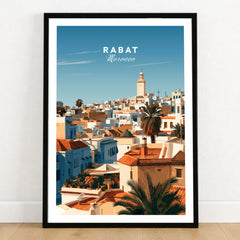 Rabat Morocco Medina Rooftops Travel Poster — medina rooftops and a pale minaret in late afternoon sun, shown as art print in black frame on wooden floor