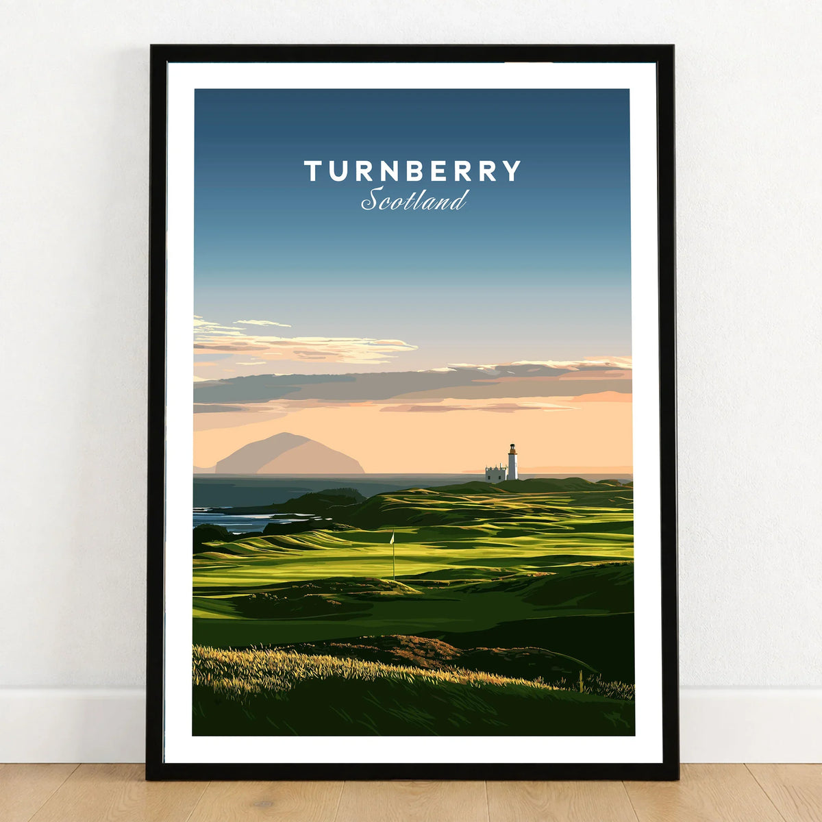Turnberry Scotland Ailsa Craig Travel Poster — Ailsa Craig and the white lighthouse across rolling coastal turf at dusk, shown as art print in black frame on wooden floor