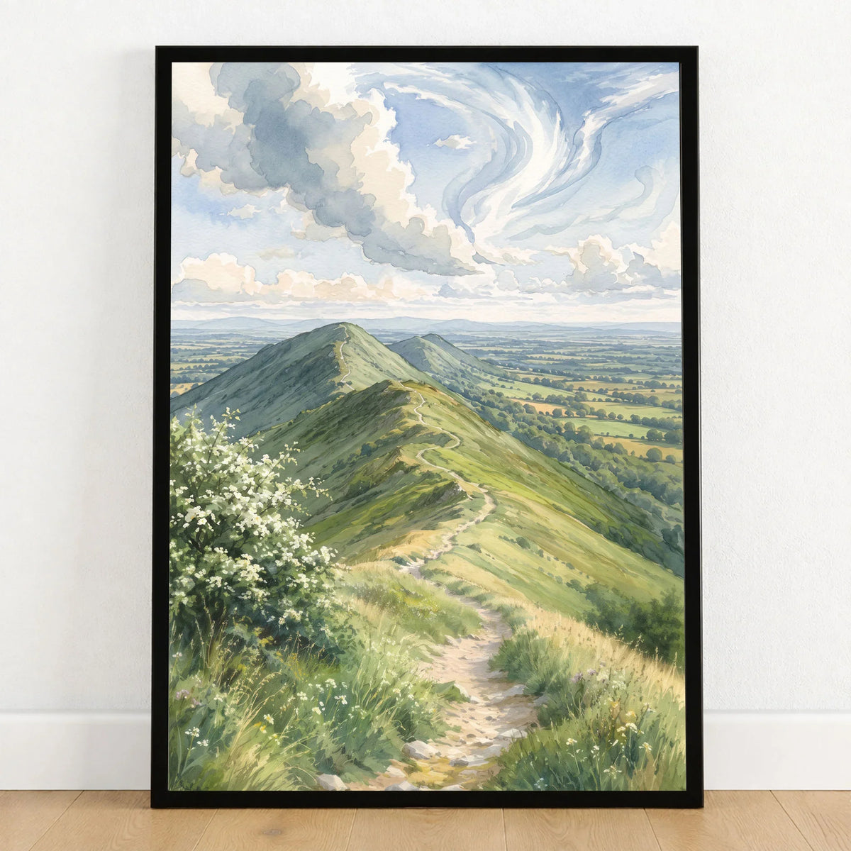 Malvern Hills ridge path watercolour art print in a black frame on a wooden floor