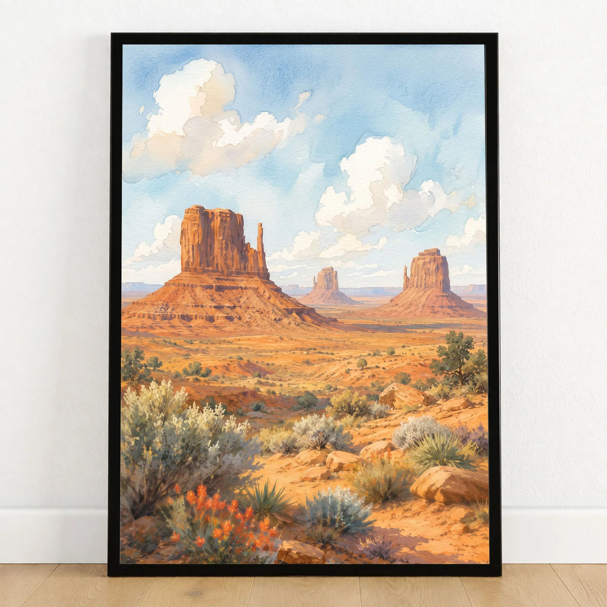 Monument Valley the Mittens buttes watercolour art print in a black frame on a wooden floor