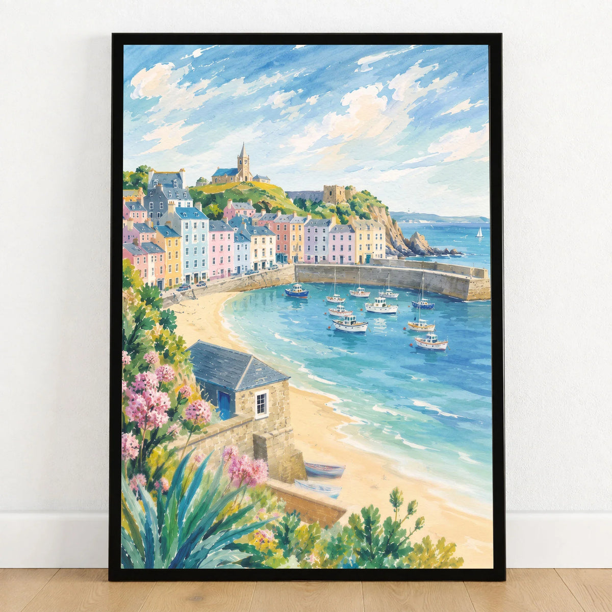 Tenby pastel harbour houses and beach watercolour art print in a black frame on a wooden floor