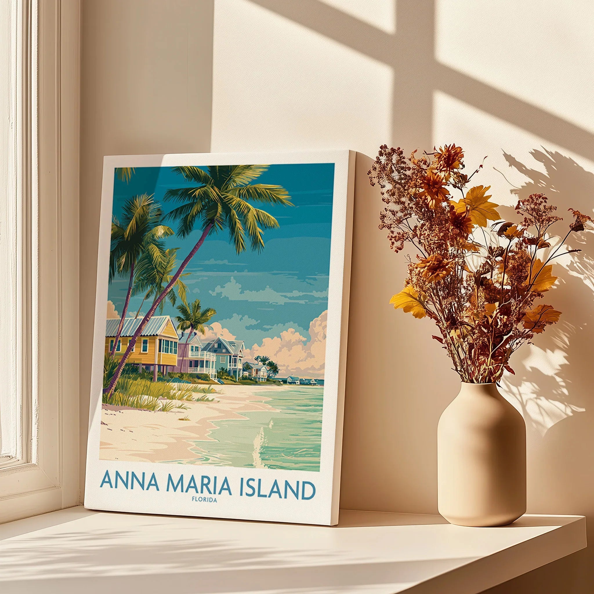 Anna Maria Island travel poster print with palm trees and beach houses on a sunny windowsill beside a vase of dried flowers.