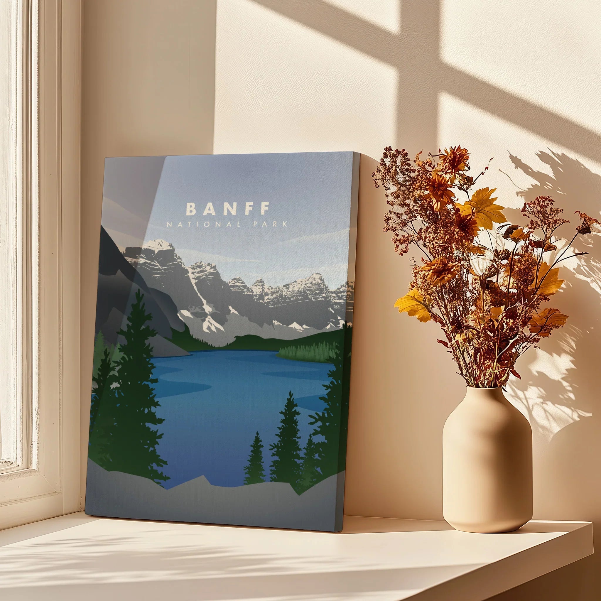 Banff National Park canvas print with mountains and lake, styled on windowsill with vase of dried flowers