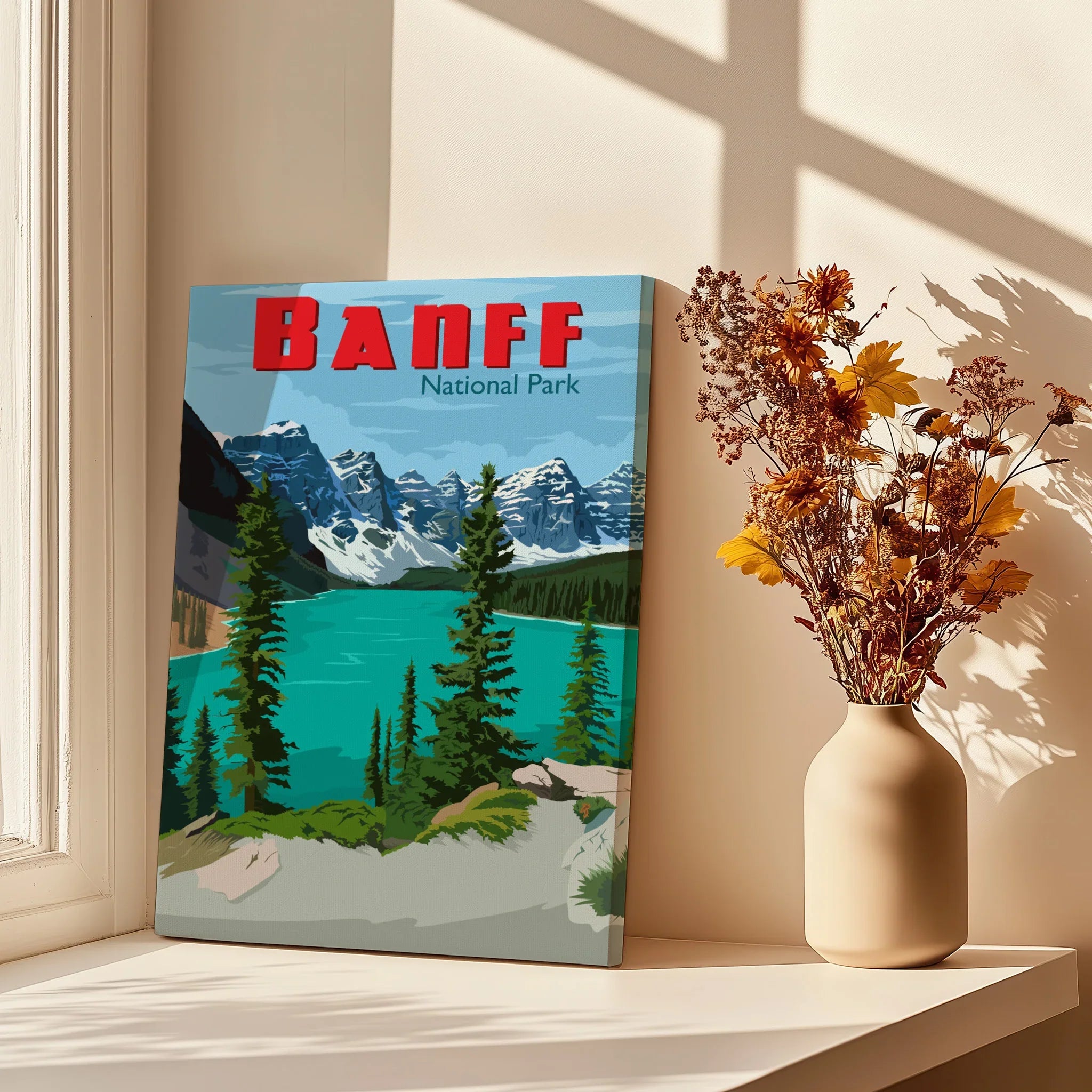 Banff National Park canvas wall art with mountain lake scene beside vase of dried flowers in sunlight