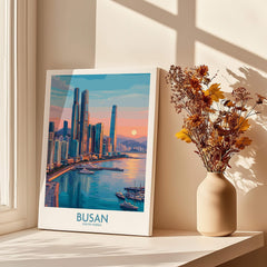 Busan city skyline canvas print on a windowsill with sunlight and a vase of dried flowers