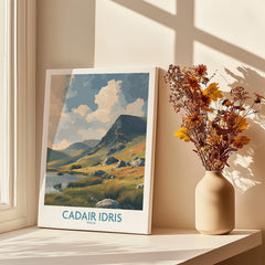 Canvas print of Cadair Idris landscape in window light, next to a vase of dried flowers.