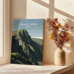 Canvas print of Cadair Idris Wales mountain art by window with vase of yellow flowers.