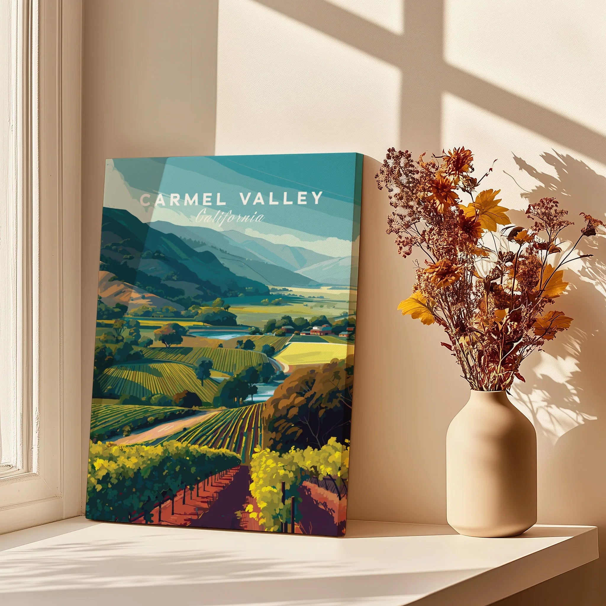 Carmel Valley California travel poster on windowsill with vase of dried flowers and sunlight.