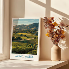 Carmel Valley travel poster print on windowsill with vase of dried flowers in sunlight