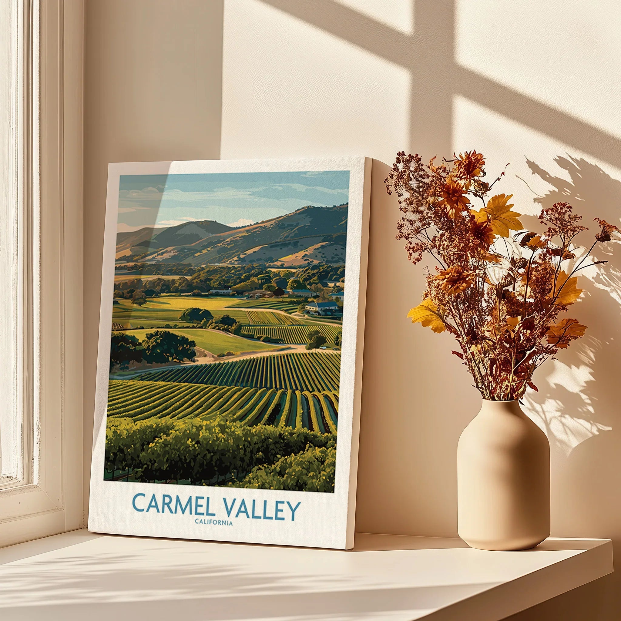 Carmel Valley travel poster print on windowsill with vase of dried flowers in sunlight