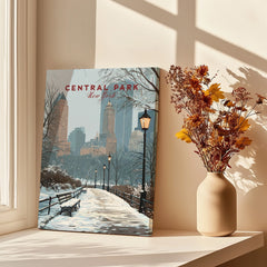 Central Park New York canvas art print with snowy city scene on a windowsill, vase of dried flowers nearby
